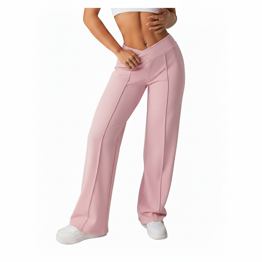 A model wearing light pink wide-leg athletic pants with a high-waisted, elastic waistband, paired with white sneakers against a plain white background.