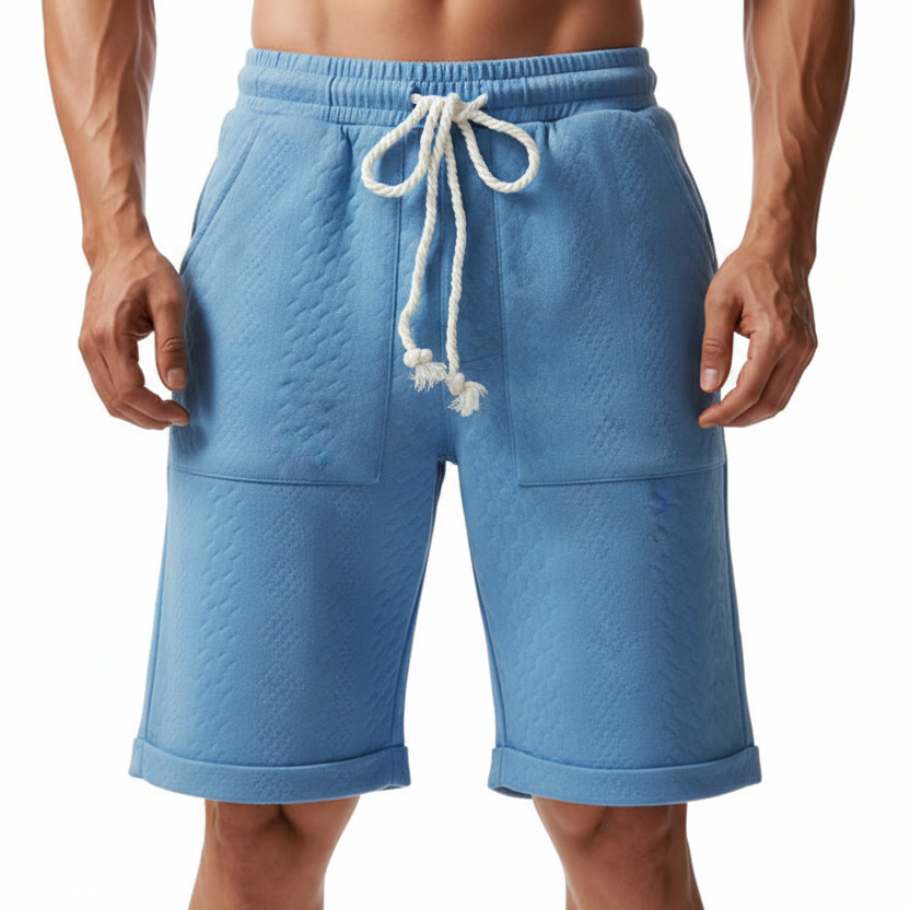 A person wearing light blue textured drawstring shorts against a plain white background.