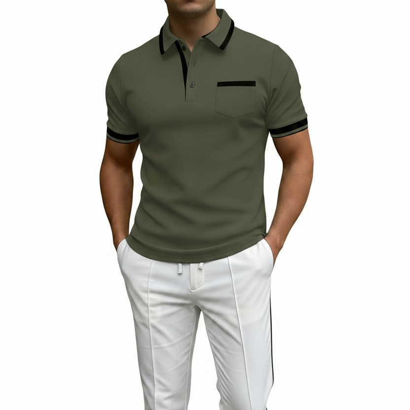 A man wearing a fitted short-sleeve polo shirt in olive green with black trim on the collar, placket, sleeve cuffs, and chest pocket, paired with white pants against a warm brown gradient background.